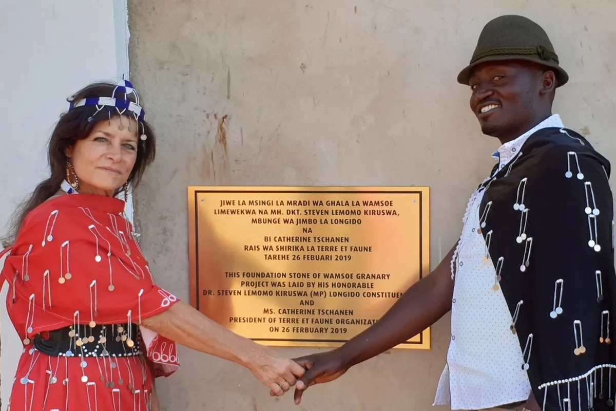 Catherine Tschanen et Emmanuel Silayo devant la plaque commémorant l'inauguration du grenier